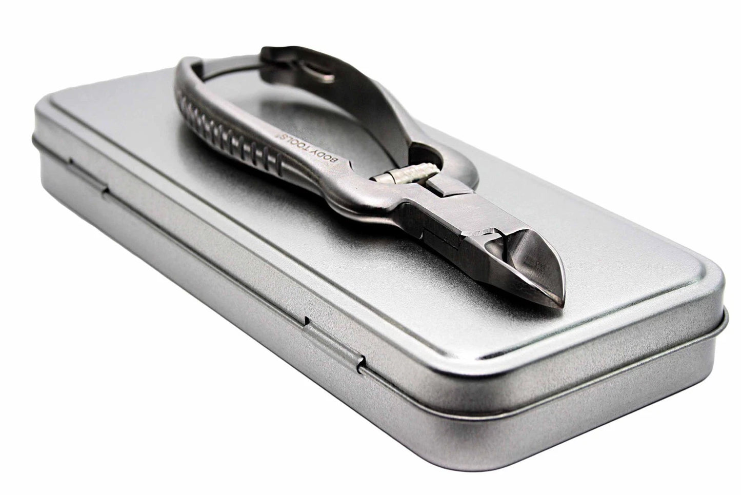 Metallic nail nipper in a tin box on a white background